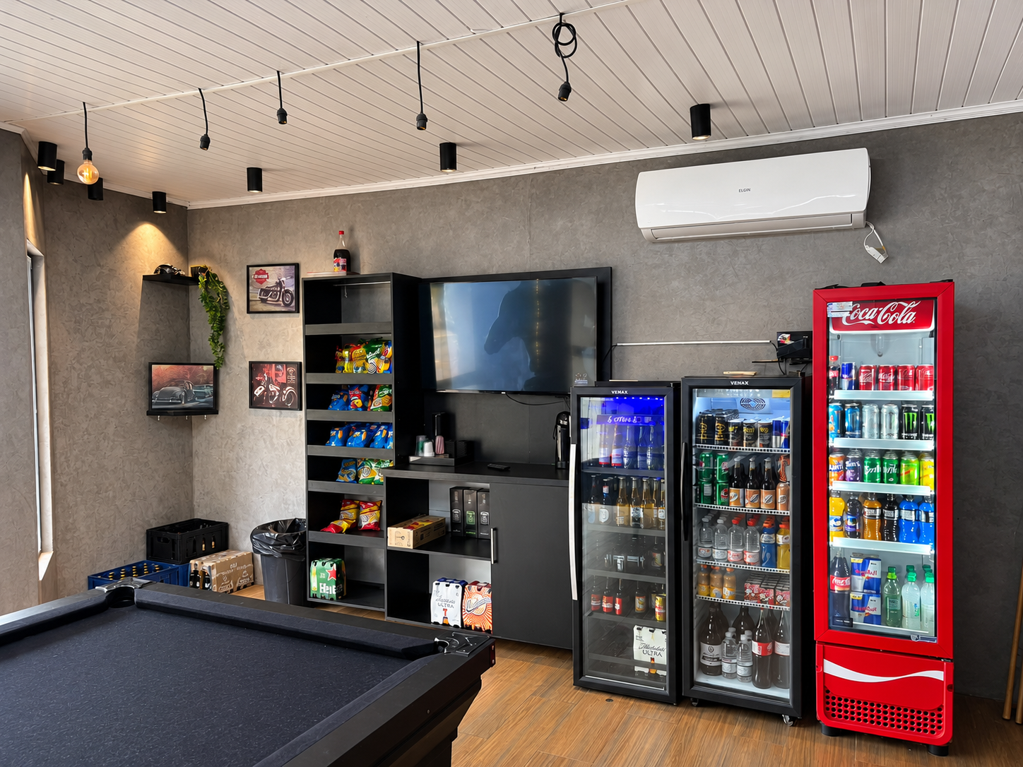 Detalhe interno da Baito Barbearia com geladeiras e televisão